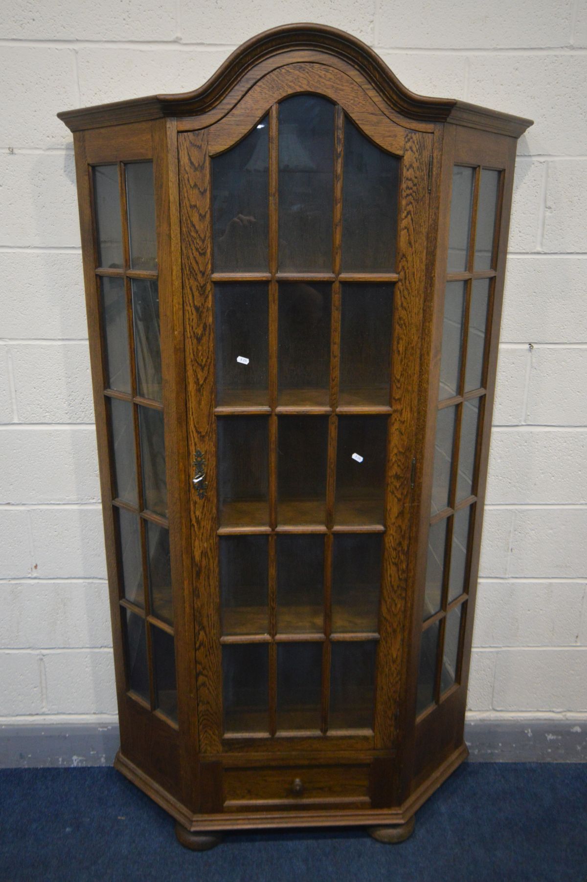 AN OAK CANTED SINGLE DOOR DISPLAY CABINET, with a single drawer, width 107cm x depth 31cm x height