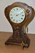 AN OAK ARTS AND CRAFTS CARVED BALLOON CASED MANTEL CLOCK, white enamel dial (s.d.), with Roman and