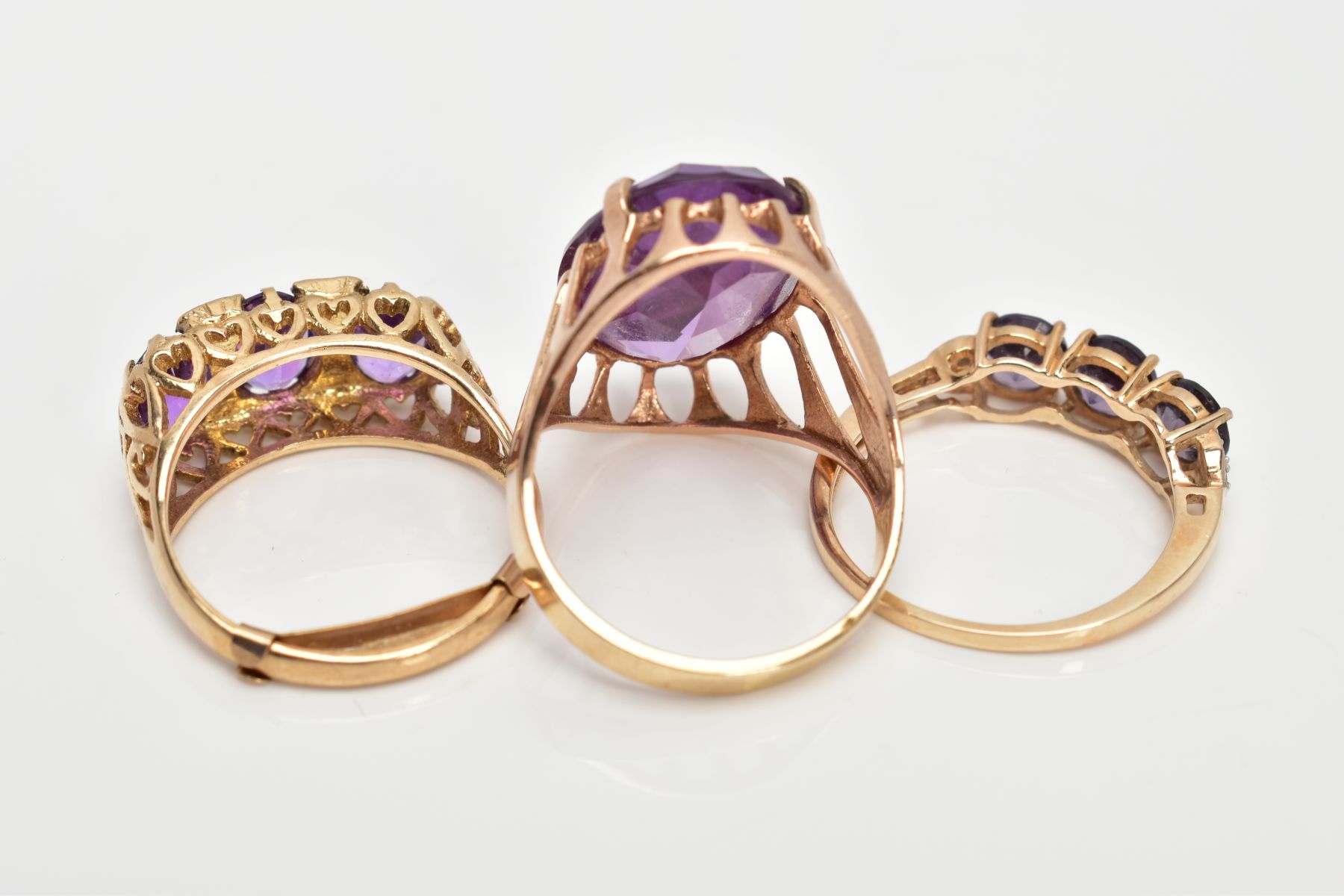 THREE 9CT GOLD AMETHYST DRESS RINGS, a large oval cut amethyst, ring size O, a three stone - Image 3 of 3