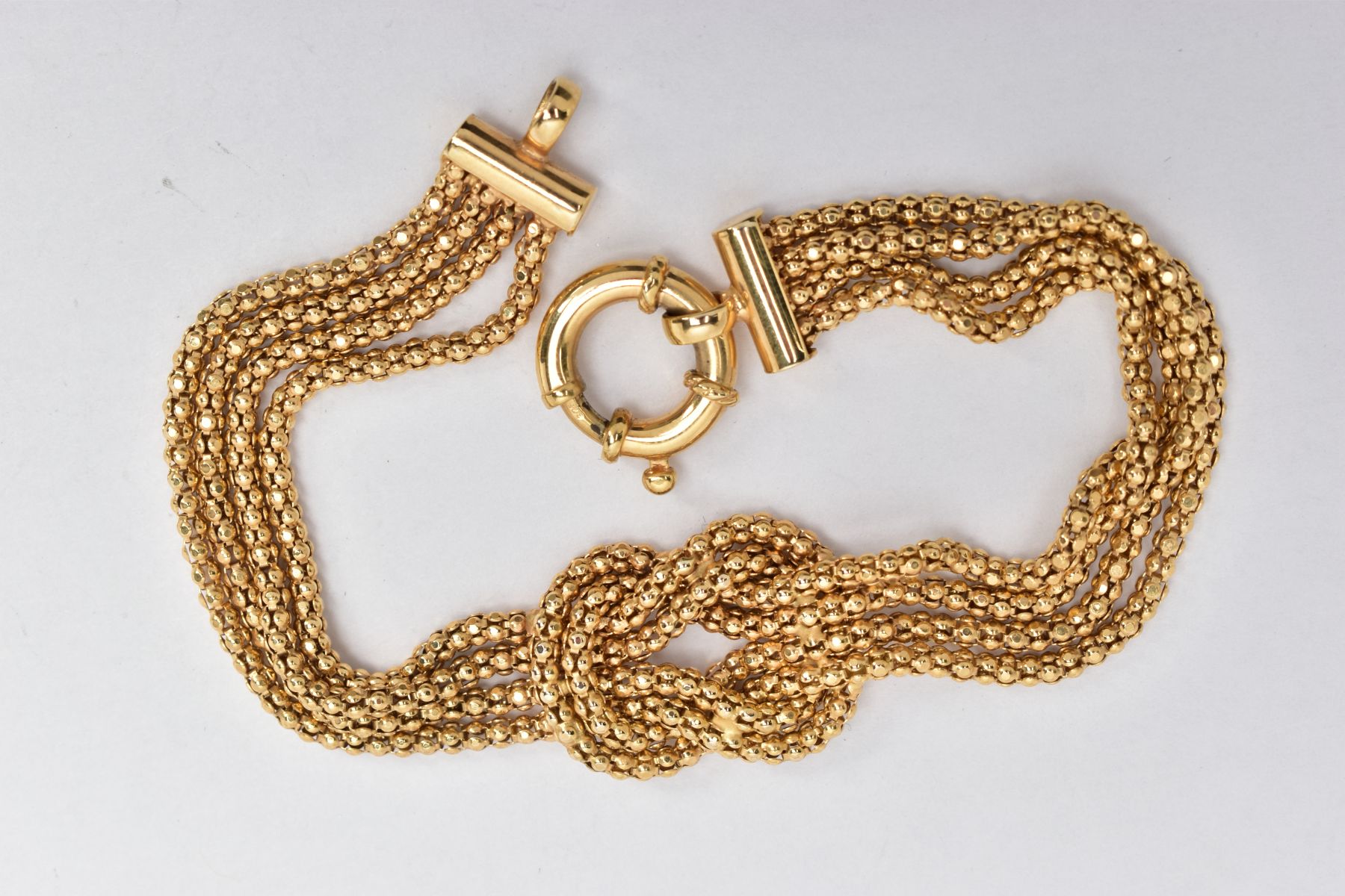 A 9CT GOLD KNOT BRACELET, four chains formed into a central knot, fitted with a large spring - Image 2 of 2