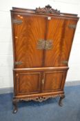 A REPRODUCTION QUEEN ANNE STYLE FLAME MAHOGANY DRINKS CABINET, two doors enclosing a mirrored