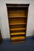 AN OAK FIVE SECTION BOOKCASE, with stencilled writing to top frieze, the bottom section with a