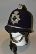 A STAFFORDSHIRE POLICE HELMET, black fabric covering, the interior lining partly perished