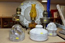 OIL LAMPS AND LAMP SHADES to include a cast metal base oil lamp with glass reservoir, aluminium