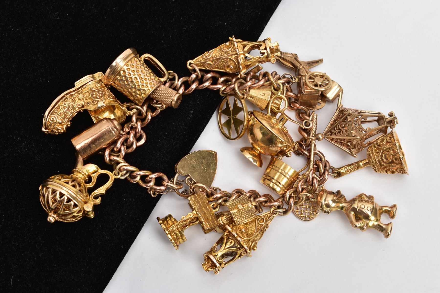 A HEAVY YELLOW METAL CHARM BRACELET, suspending nineteen charms in forms such as a wishing well, - Image 2 of 2