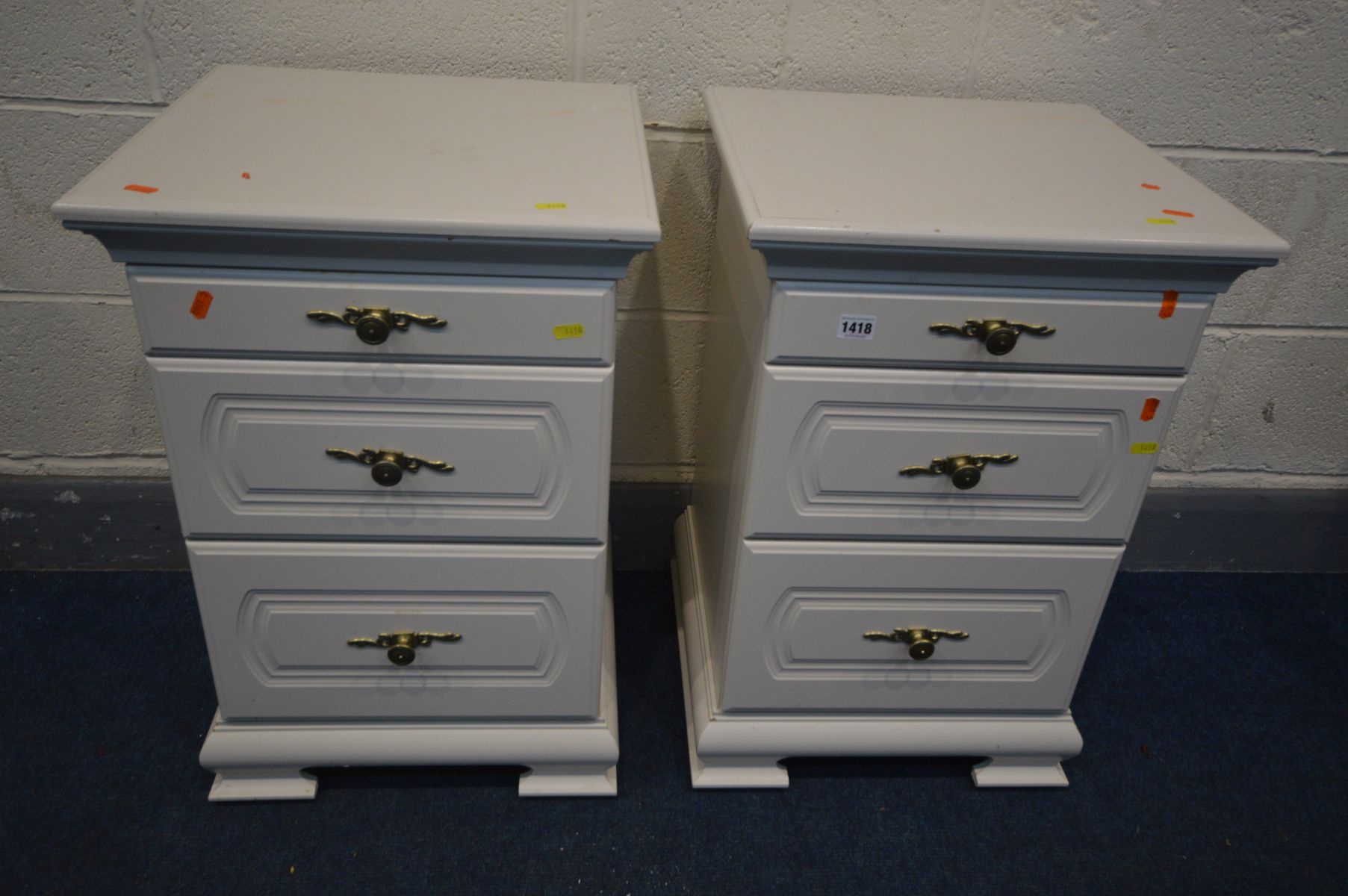 A PAIR OF WHITE THREE DRAWER BEDSIDE CABINETS, the top drawers with a pull out glass surface, on