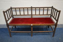 A LATE 19TH/EARLY 20TH CENTURY BEECH BOBBIN TURNED SETTEE, with red upholstery , width 117cm x depth