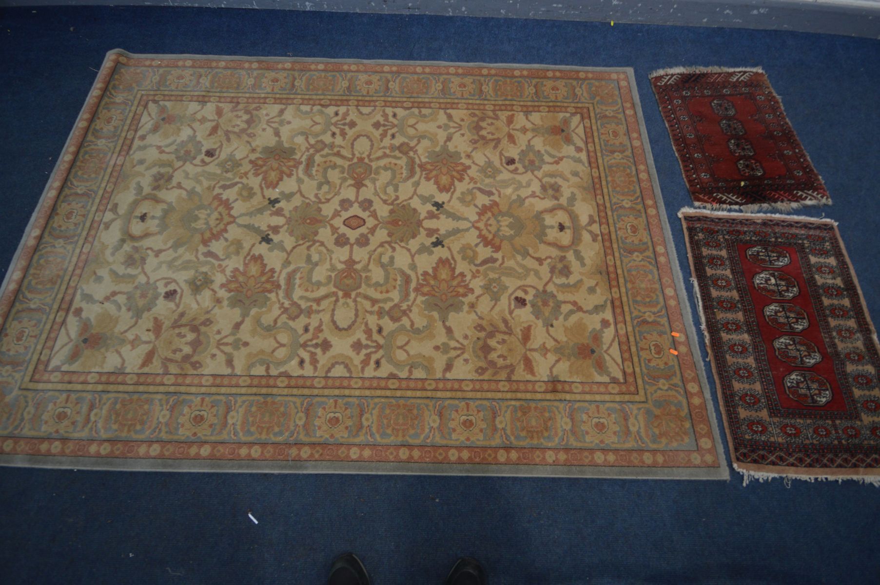 A FLORAL WOOLLEN RUG, labelled Abbey, 240cm x 170cm and two small tekke rugs, in a red field (3)