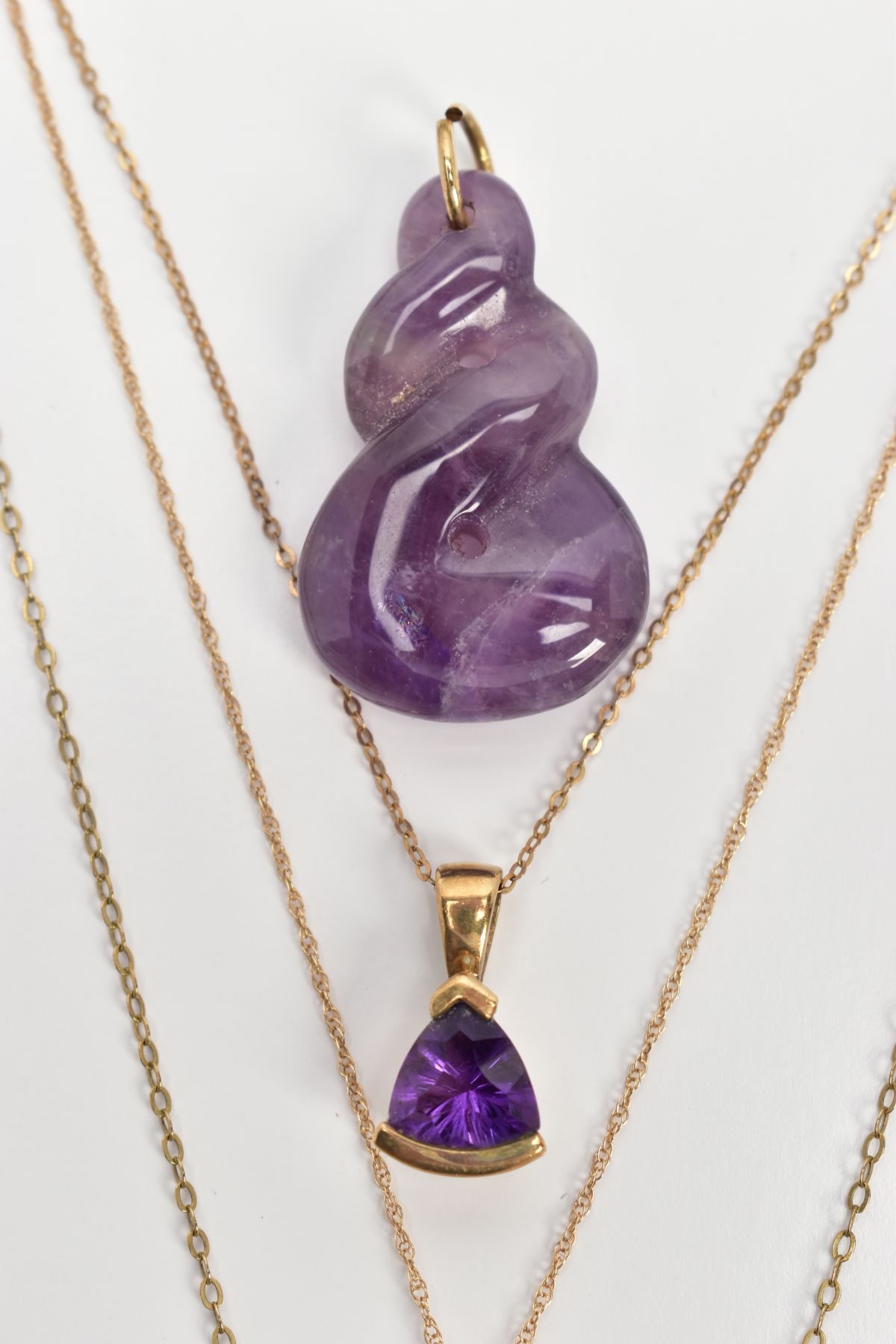 THREE AMETHYST PENDANT NECKLACES AND A CARVED AMETHYST PENDANT, the first a faceted pear cut - Image 3 of 3