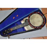 A RELIANCE UKELELE-BANJO IN A CARRY CASE, comes with a small quantity of sheet music