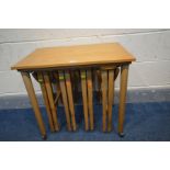 IN THE MANNER OF POUL HUNDEVAD, a mid-century teak nesting tables, with four fold out tables