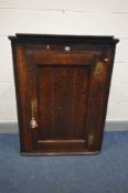 A GEORGIAN OAK HANGING CORNER CUPBOARD, panelled door enclosing three fixed shelves, width 82cm x