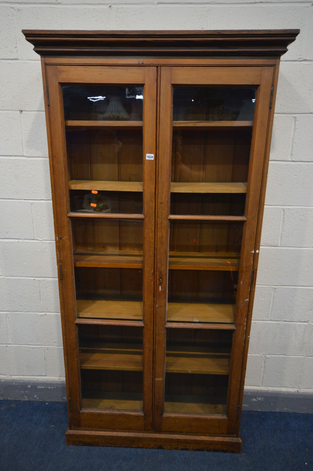 AN EARLY 20TH CENTURY PITCH PINE BOOKCASE, with double glazed doors enclosing five adjustable
