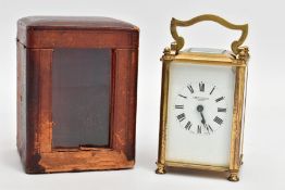 A BRASS CARRIAGE CLOCK WITH LEATHER CASE AND A KEY, the brass framed and glass panel clock, white