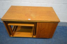 A TEAK COFFEE TABLE, with a rotating and fold over top, nest of two tables stored below and a fall