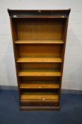 AN OAK FIVE SECTION BOOKCASE, with stencilled writing to top frieze, the bottom section with a
