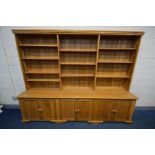 A LARGE LIMED OAK BOOKCASE, the three division top section with twelve adjustable shelves, above