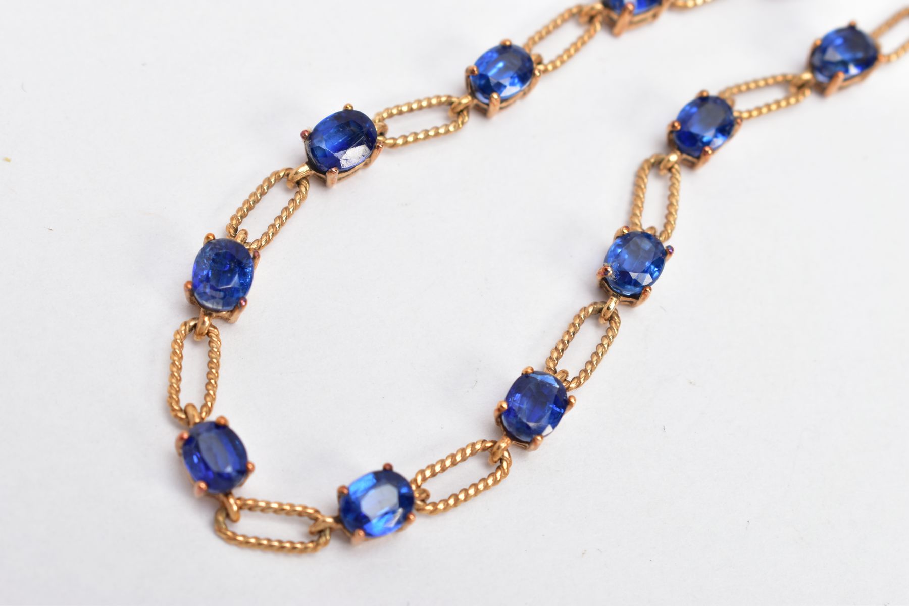 A 9CT GOLD KYANITE SET LINE BRACELET, designed with thirteen oval cut kyanites, interspaced with - Image 2 of 3