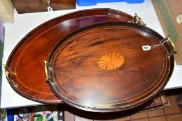 TWO EDWARDIAN MAHOGANY STAINED BEECH AND INLAID OVAL TWIN HANDLED TRAYS, brass scrolled handles, the