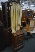 A STAINED PINE CHAPEL CURTAIN SCREEN ON PLINTH, width 49cm x depth 34cm x height 192cm (