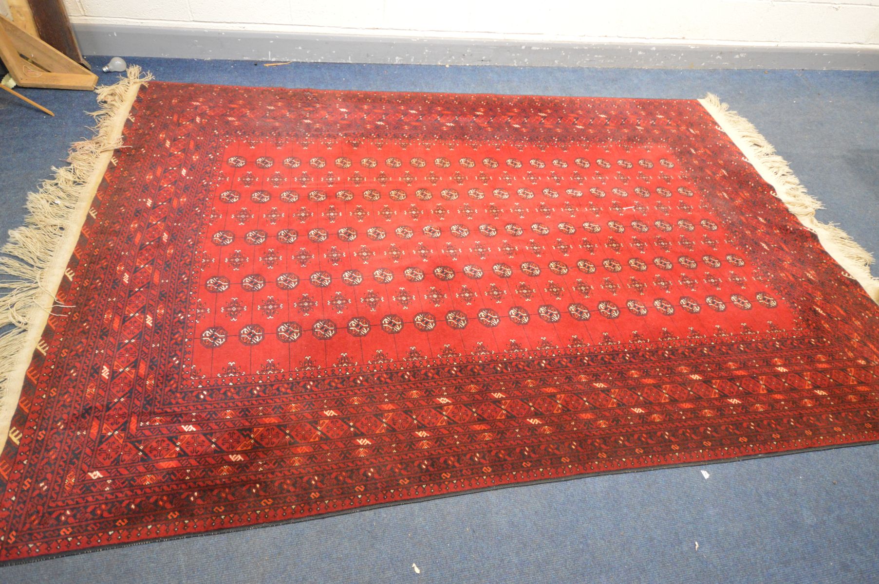 A 20TH CENTURY RED GROUND TEKKE RUG, 304cm x 200cm