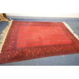 A 20TH CENTURY RED GROUND TEKKE RUG, 304cm x 200cm