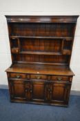 A TITCHMARSH AND GOODWIN OAK DRESSER, with three frieze drawers and triple fielded panel cupboard