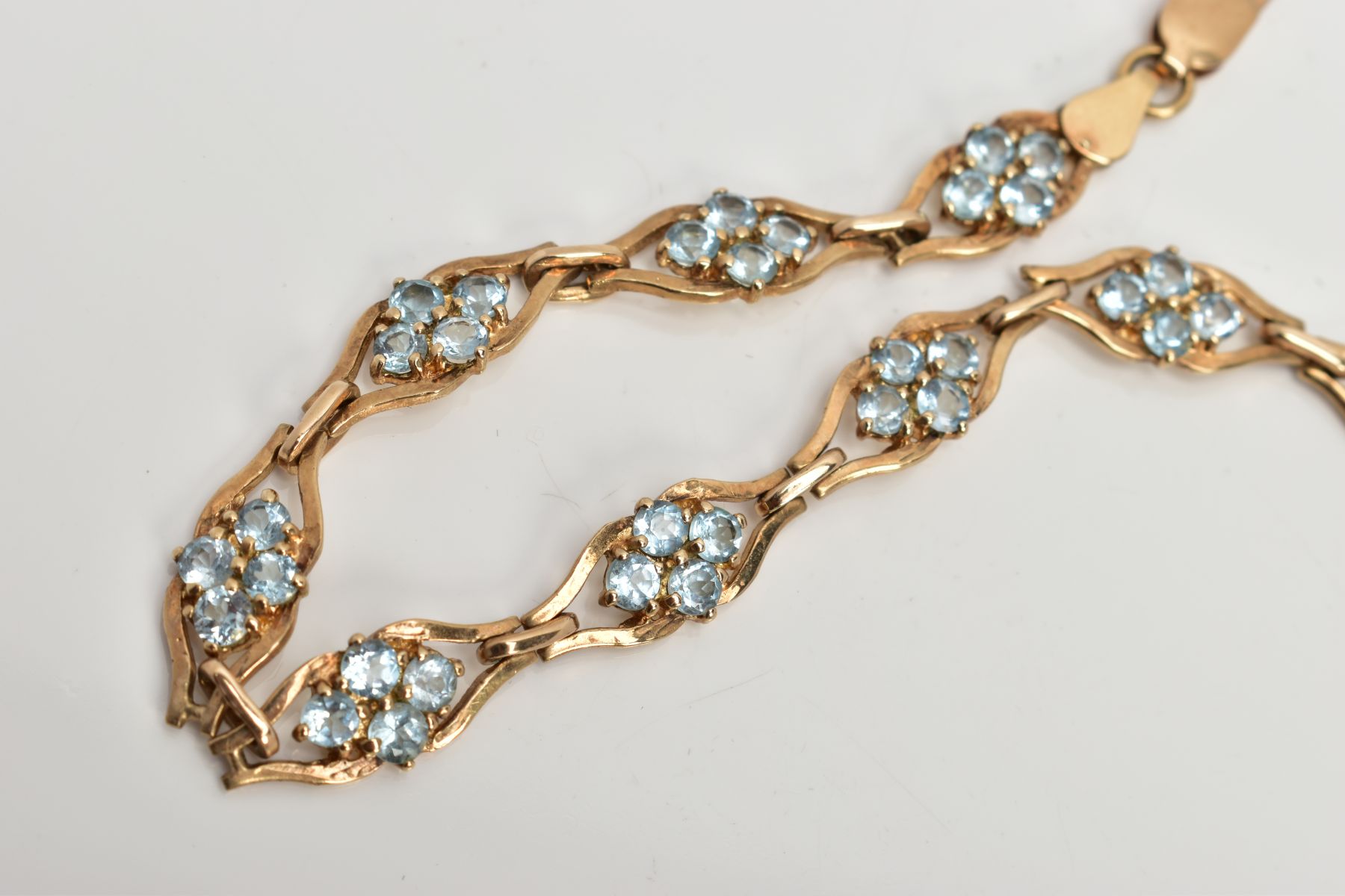 A 9CT GOLD TOPAZ LINE BRACELET, designed with nine openwork links, each set with four circular cut - Image 2 of 3