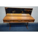 AN AUSTINSUITE TEAK DRESSING TABLE, with a long rectangular mirror, three frieze drawers, on twin