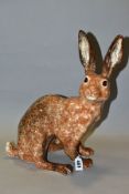 A WINSTANLEY POTTERY MOTTLED BROWN FIGURE OF A SEATED HARE, glass eyes, painted marks to underside