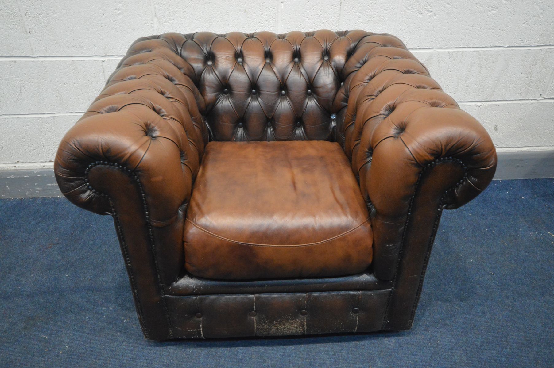 A BROWN LEATHER CHESTERFIELD CLUB CHAIR, width 101cm x depth 84cm x height 73cm (condition:- pet