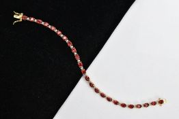 A SELECTION OF JEWELLERY, to include a silver gilt line bracelet, set with oval cut garnets,
