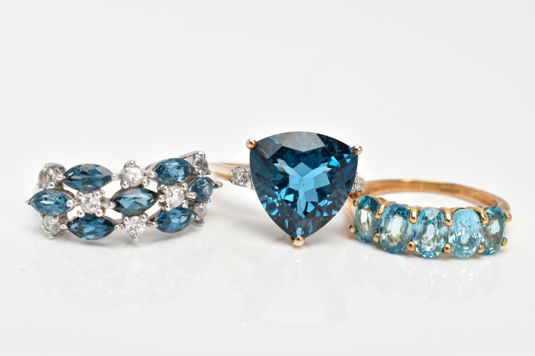 THREE 9CT GOLD GEM SET DRESS RINGS, the first a 9ct white gold ring set with blue and colourless