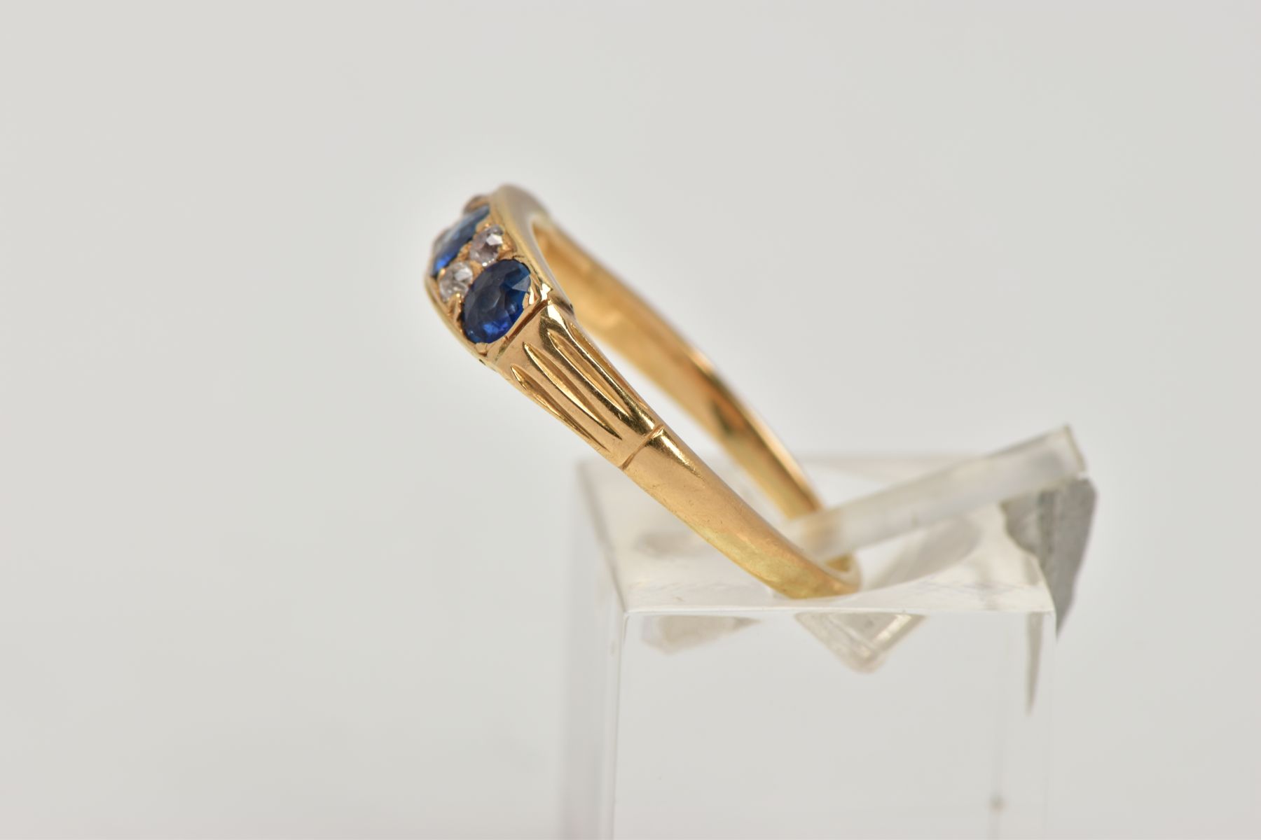 A YELLOW METAL SAPPHIRE AND DIAMOND RING, designed with a row of three circular cut blue - Image 2 of 4