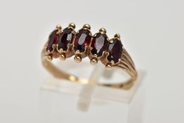 A 9CT GOLD FIVE STONE GARNET RING, designed with five oval cut garnets, applied bead work to the