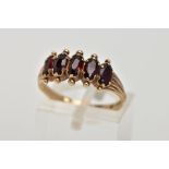 A 9CT GOLD FIVE STONE GARNET RING, designed with five oval cut garnets, applied bead work to the