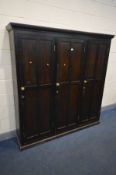 AN EARLY 20TH CENTURY STAINED PINE AND BEECH PANELLED TRIPLE DOOR HOUSEKEEPERS CUPBOARD, enclosing