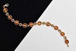 A 9CT GOLD AMBER SET LINE BRACELET, designed with ten circular cut amber set links, interspaced with