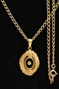 A 9CT GOLD ONYX PENDANT AND CHAIN, an oval pendant centring on a oval onyx disk with an applied