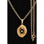 A 9CT GOLD ONYX PENDANT AND CHAIN, an oval pendant centring on a oval onyx disk with an applied