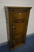 A MODERN OAK AND METAL GUN CABINET, the single door opening to reveal green baize lined interior,