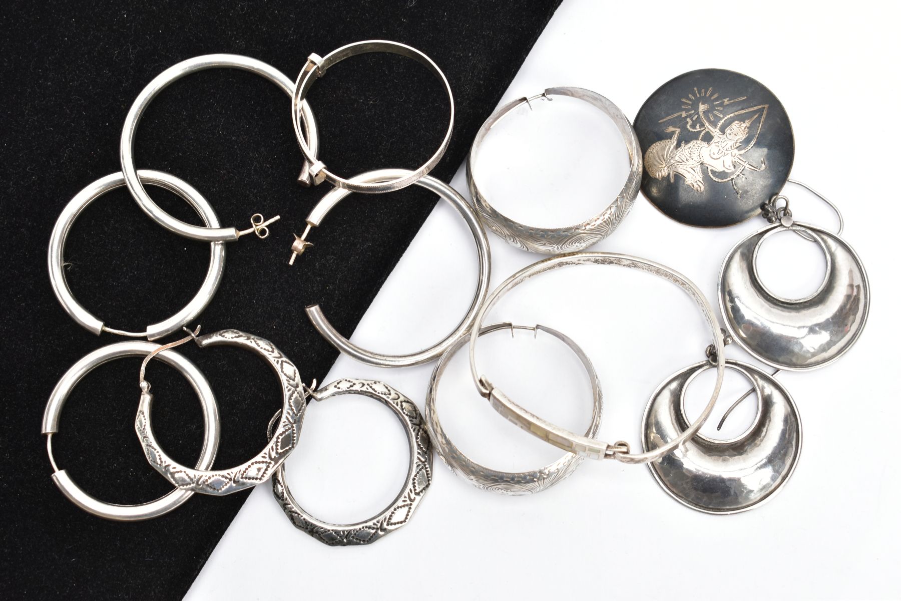 A SELECTION OF WHITE METAL EARRINGS, BANGLES AND A BROOCH, to include two pairs of polished hoops,