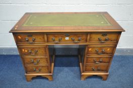 A YEWWOOD PEDESTAL DESK with a green gilt tooled leather top, and nine assorted drawers, width 107cm