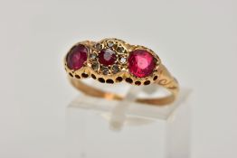 AN EARLY 20TH CENTURY 18CT GOLD RING, designed with three circular cut red stones assessed as garnet