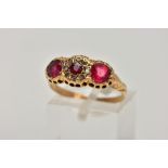 AN EARLY 20TH CENTURY 18CT GOLD RING, designed with three circular cut red stones assessed as garnet
