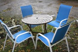 A CIRCULAR TEAK SLATTED FOLDING GARDEN TABLE together with a set of four white metal lounge garden