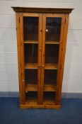 A PINE DOUBLE DOOR GLAZED BOOKCASE with three adjustable shelves and internal lighting, width 90cm x