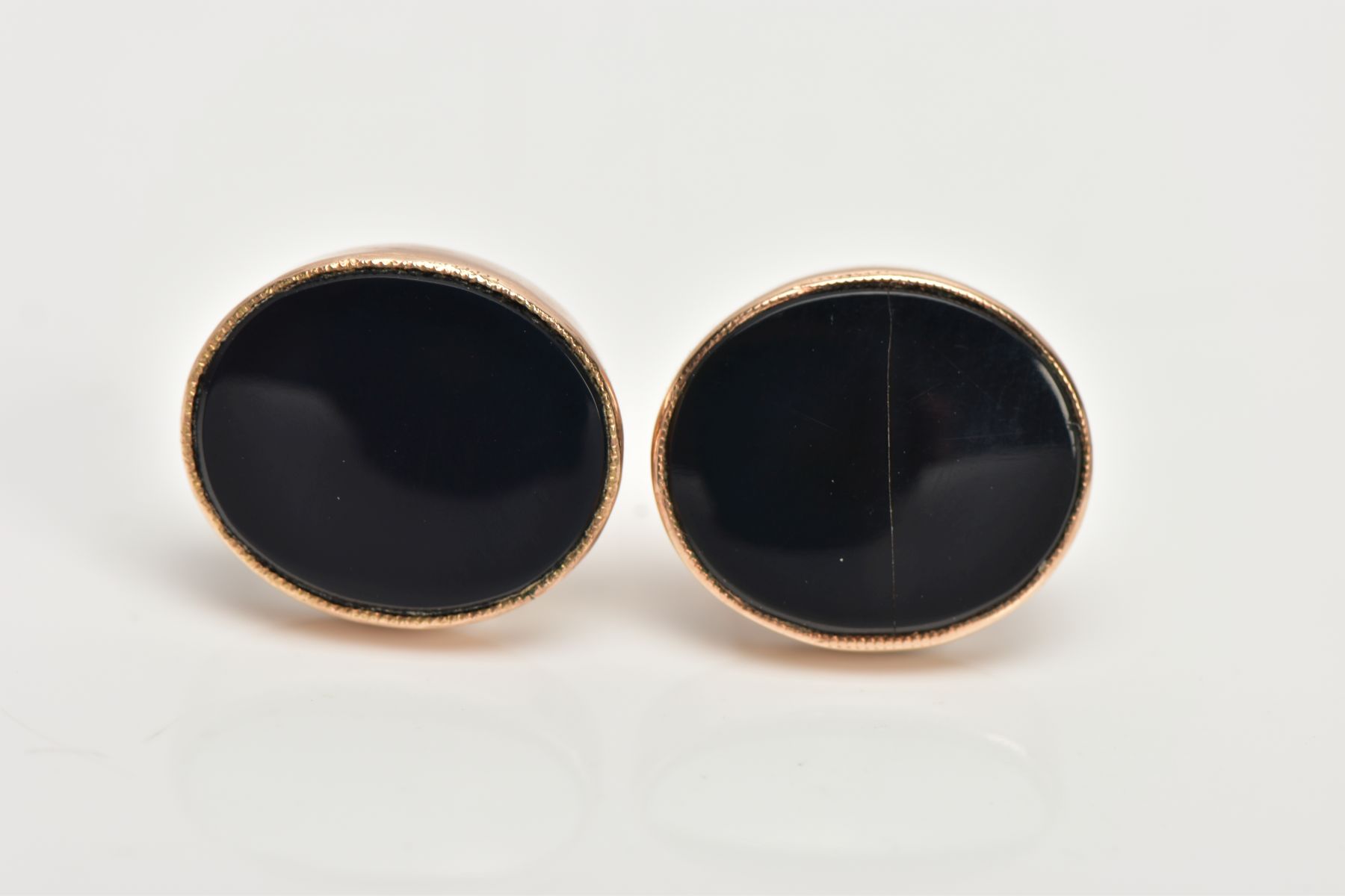 A PAIR OF YELLOW METAL ONYX EARRINGS, each designed with an oval onyx, collet mounted, approximate
