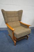 A MID CENTURY TEAK FRAMED ROCKING WING BACK ARMCHAIR (this chair does not comply with the