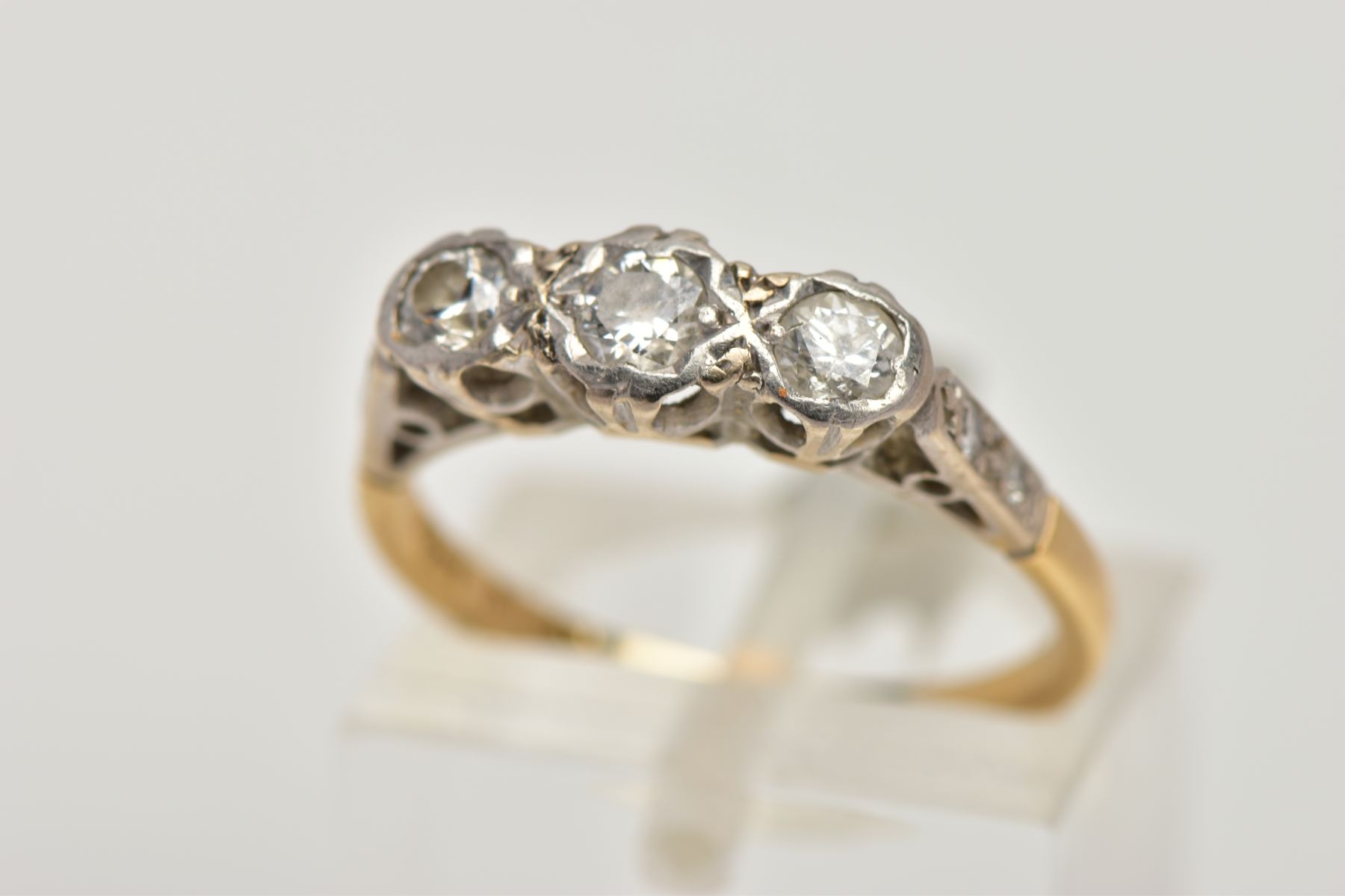 A THREE STONE DIAMOND RING, designed as three graduated brilliant cut diamonds with single cut